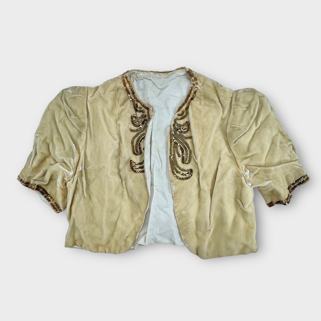 Antique Ivory Velvet Shrug with Gold Sequins. No Maker Label.: Presenting some spots and soiling. Measurement taken flat. Shoulders 13 in. Chest 17 in.
