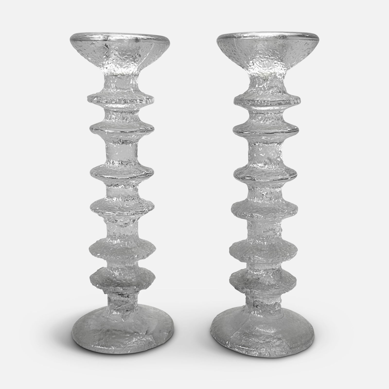 Timo Sarpaneva for Iittala Pair of Festivo Glass Candleholders: Ca. 1970s. Six-ring recycled glass candeholders by Timo Sarpaneva for Iittala. Very good condition with one chip to base of one candlestick. We do not provide in-house shipping! Please reach out to Do