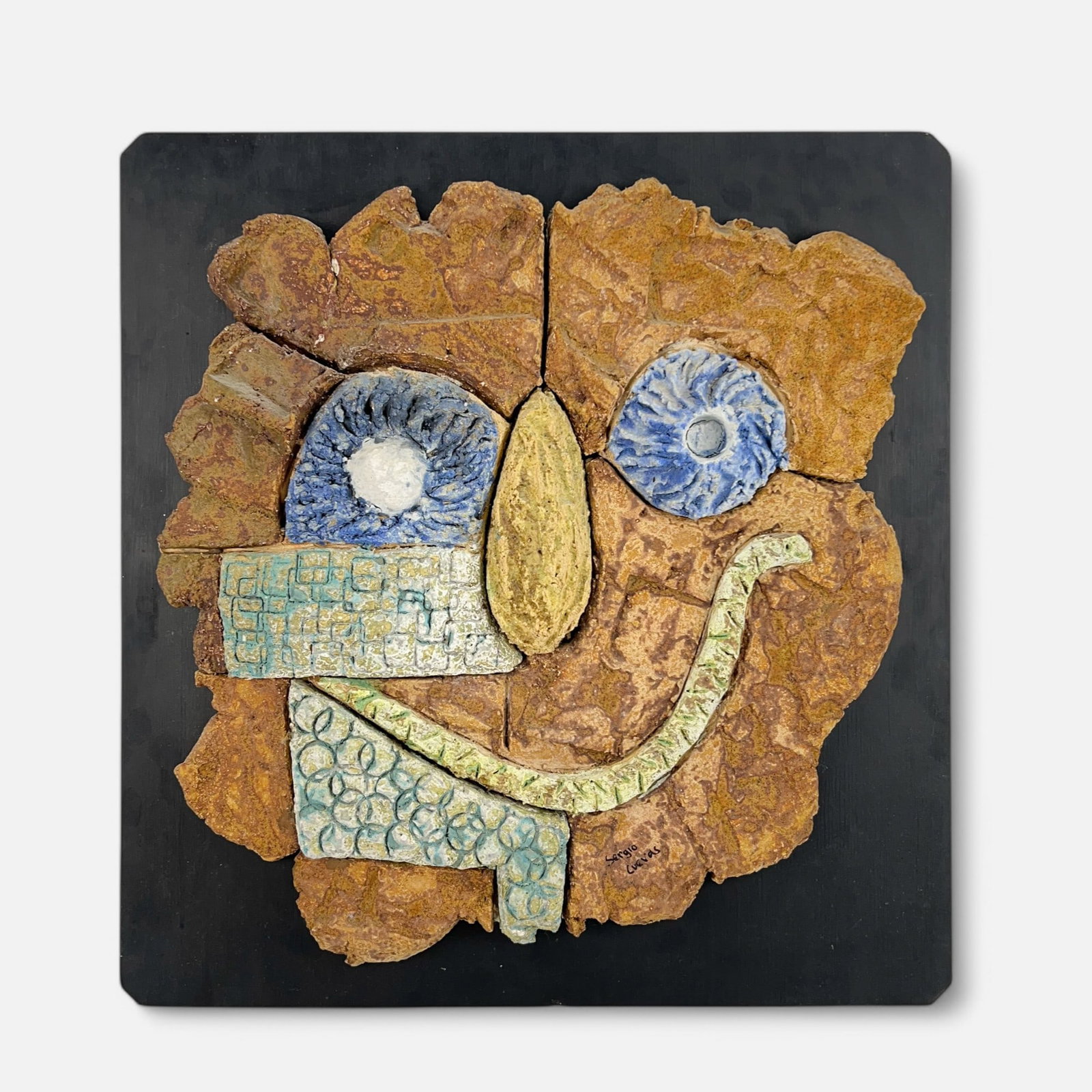 Sergio Cuevas Corona Mexican Folk Art Face Sculpture Mounted to Wood Board: Somewhat loose from board and will likely need to be reglued. With a few minor chips along edge of piece. Just sculpture measures approx. 22" x 21 1/2".