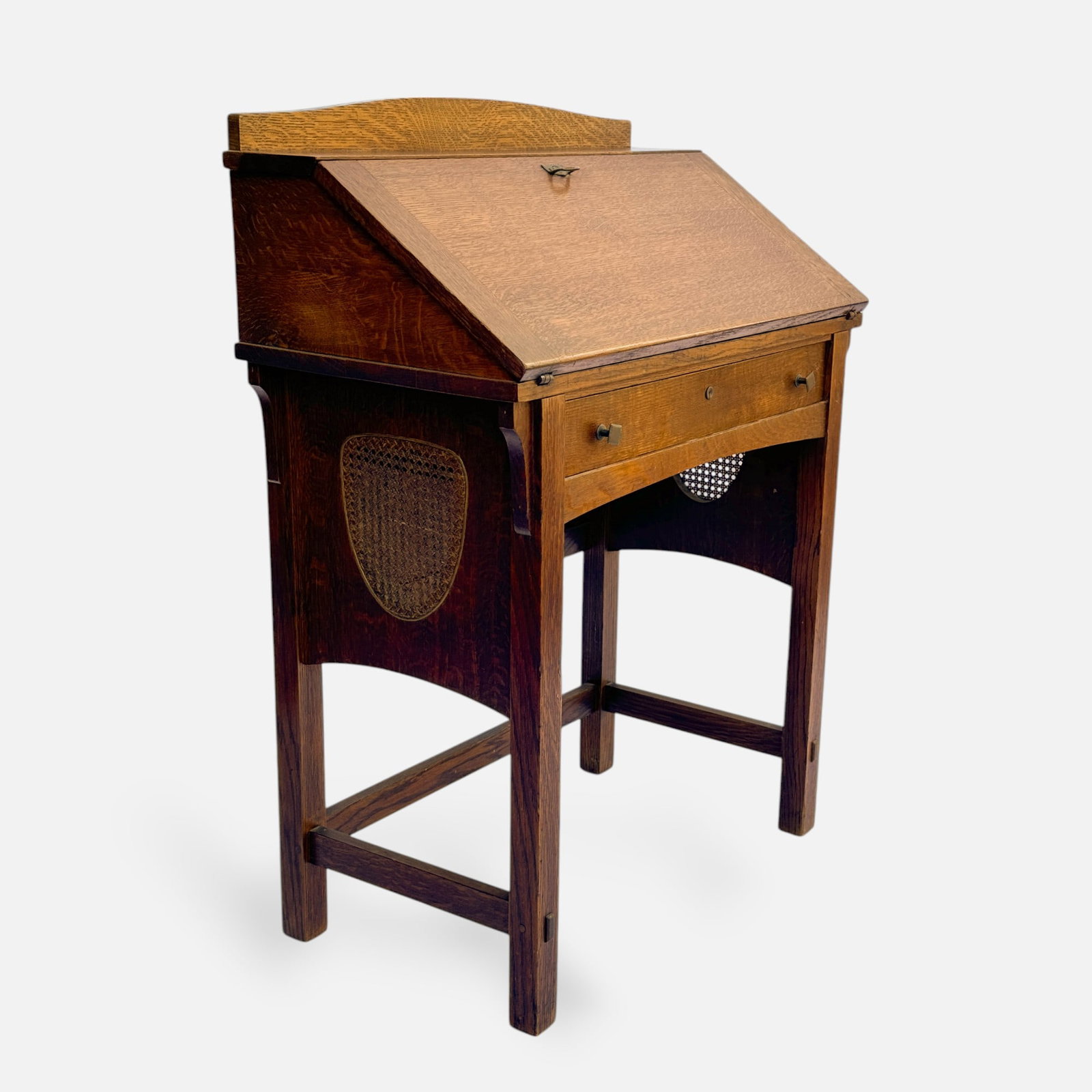 Limberts Arts & Crafts Mission Oak Drop Front Desk: Ca. first quarter 20thC. Very good age-appropriate condition. With minor divots to right top of drop front. Very nice mellow surface, with no breaks or rips within the rattan panels. Brand inside draw