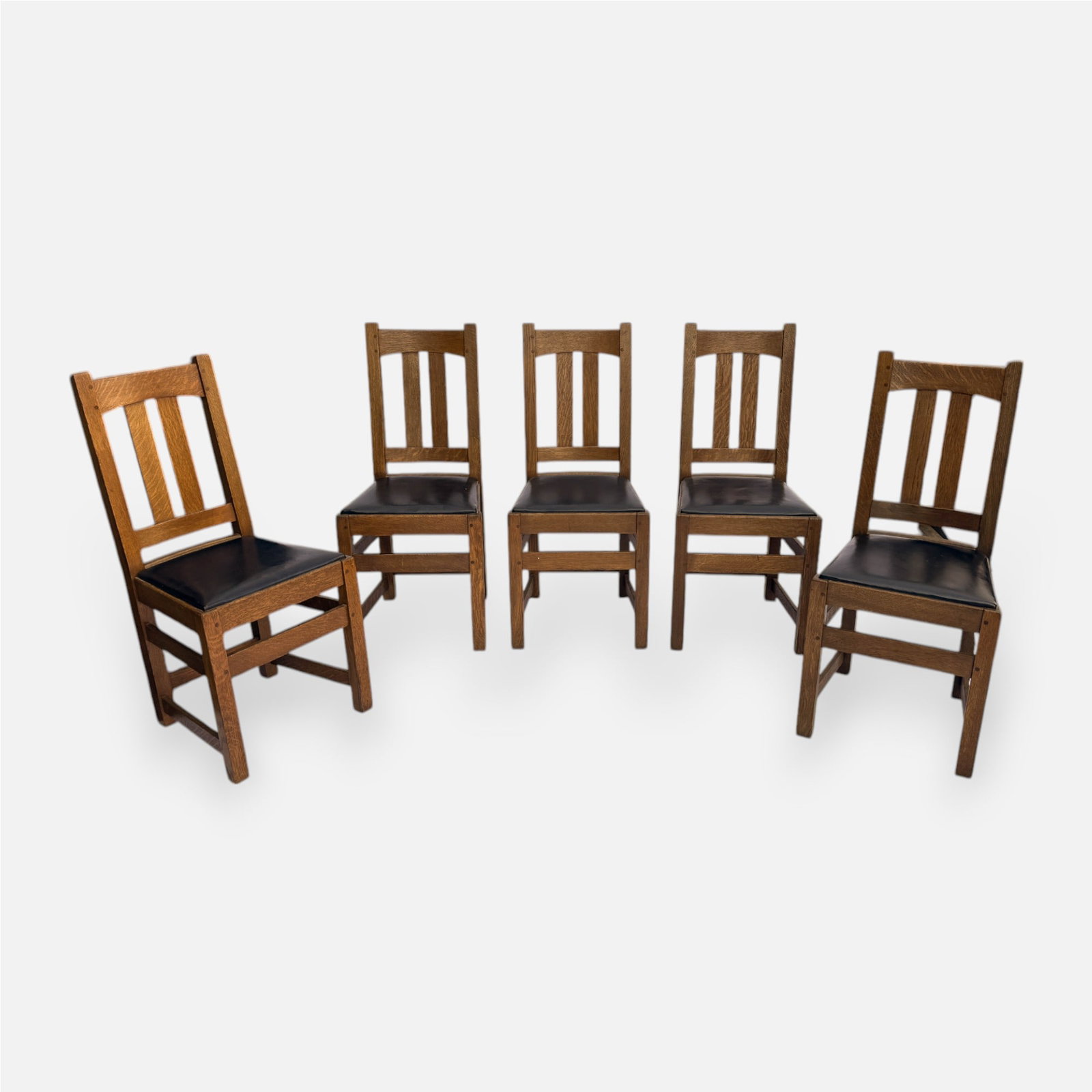 Set of Five Limberts Arts & Crafts Mission Oak Dining Chairs: Ca. first quarter 20thC. Very good age-appropriate condition, with no breaks or repairs. Retains original finish throughout. Likely replaced leather seats. Brand on stretcher. Approx. seat H: 17 3/4",