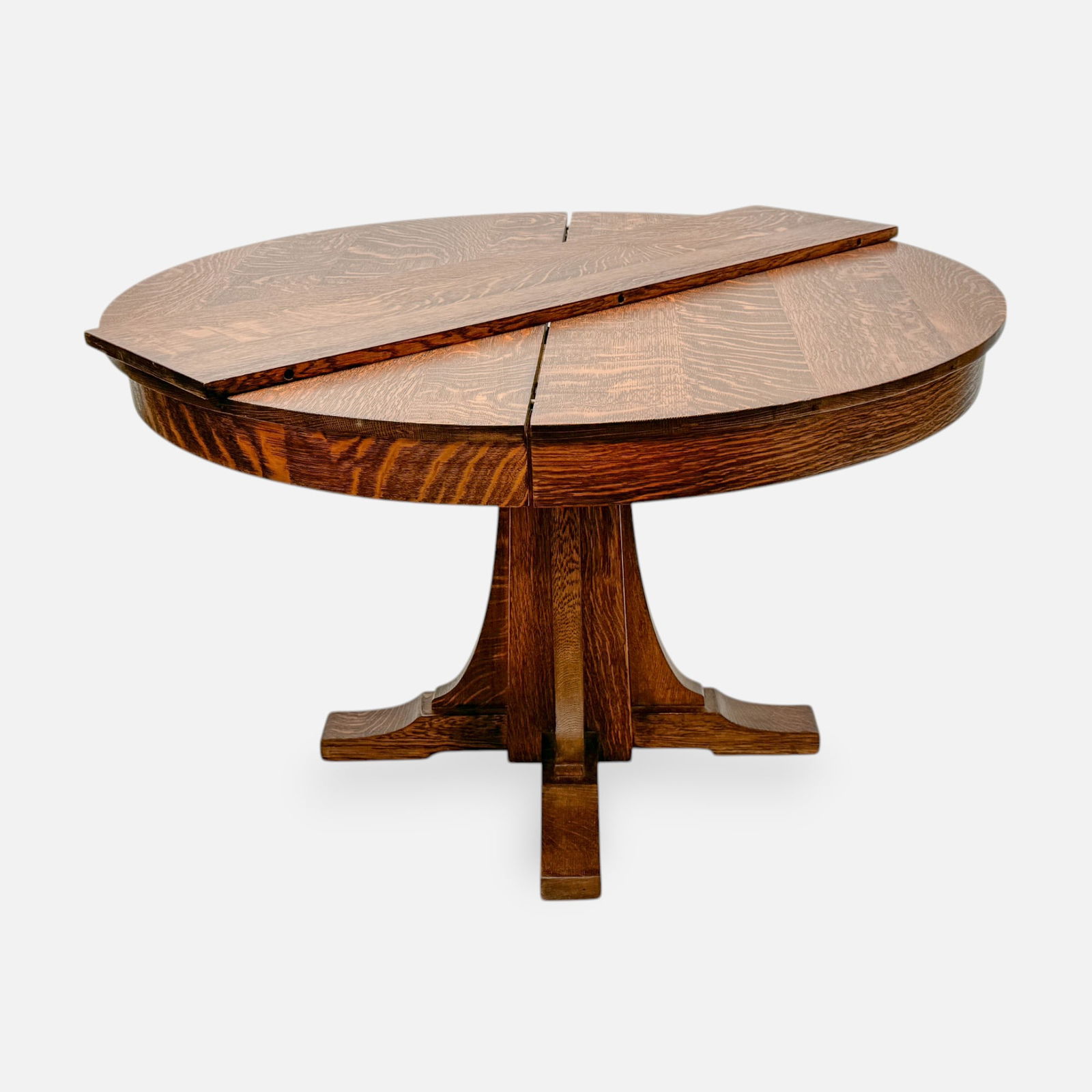 L. & J.G. Stickley Arts & Crafts Mission Oak Extending Pedestal Table: Ca. early 20thC. Very good as shown with minor surface scratches and scuffs consistent with age and use. Retains a rich, beautiful original patina. Each of the four leaves measure approx. 12". See fin