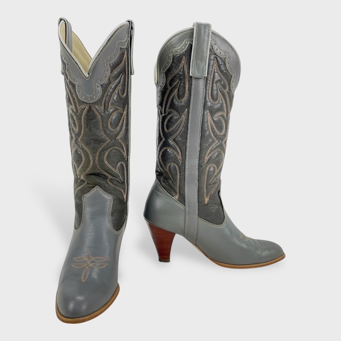 Vintage Capezio Ladies Size 6M Gray Leather Cowboy Boots: Vintage Capezio Gray Leather Cowboy Boots w/ Black Shaft, Western Stitching, Pull Straps, Scalloped Collar, Stacked Heel, And Leather Outsoles Showing Wear. We do not provide in-house shipping! We hav