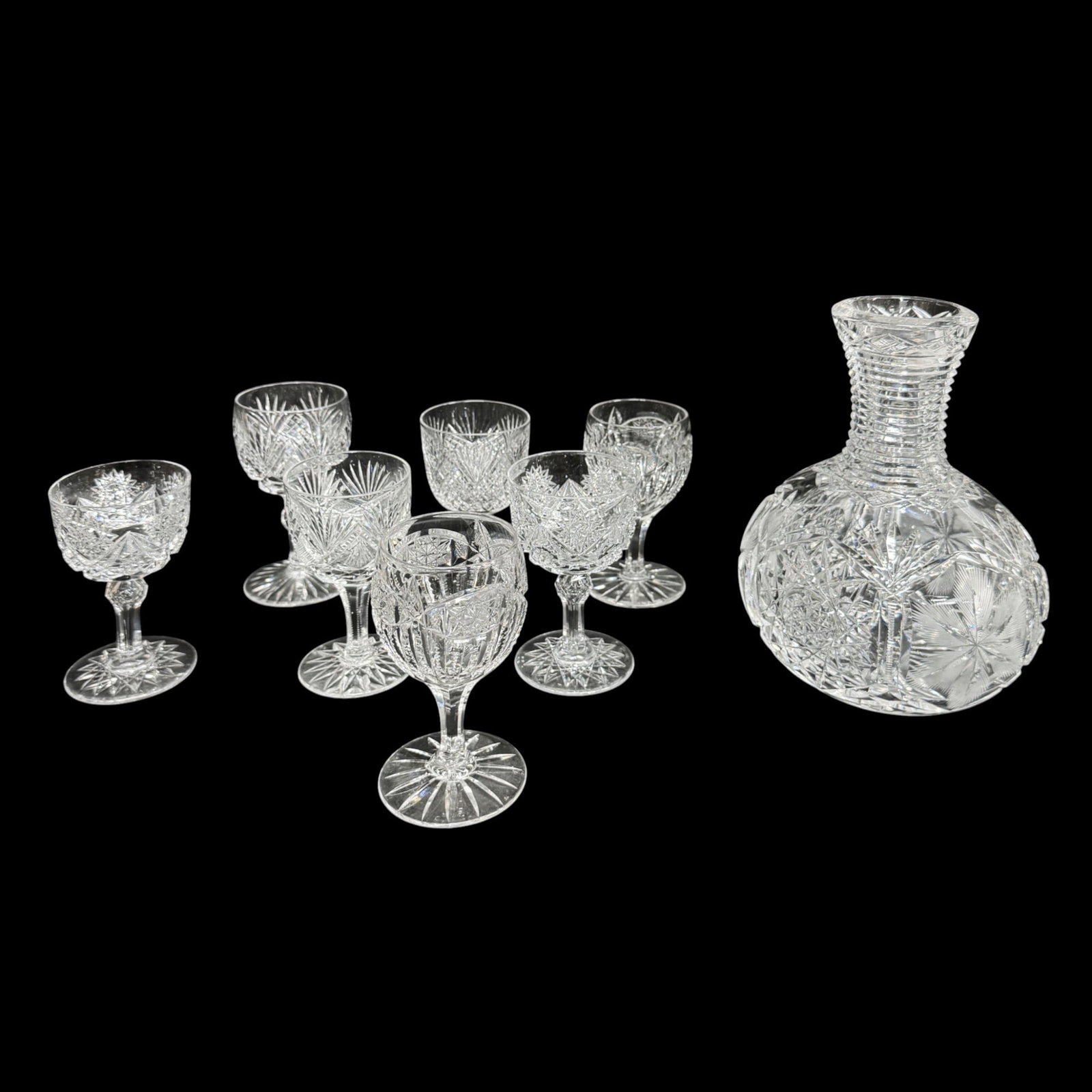 Antique American Brilliant Cut Glass Carafe and Seven Wine Glasses: Ca. 19th/20thC. Possible chip(s), however, overall very good condition with no major chips, no cracks. Glasses of slightly varied sizes, the largest measuring 4 3/4" x 2 1/2". IMPORTANT: Pickups and s
