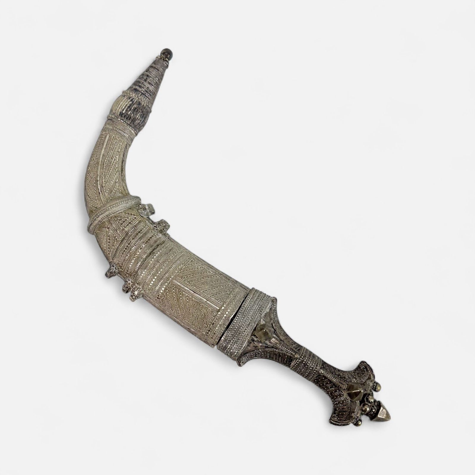 Silver Islamic Yemini Jambiya Dagger: Ca. first half 20thC. Fair to good age-appropriate condition, with shown surface discoloration, polish residue, minor hole(s)/crack(s). Blade measures approx. 7". Overall sheathed dimensions included