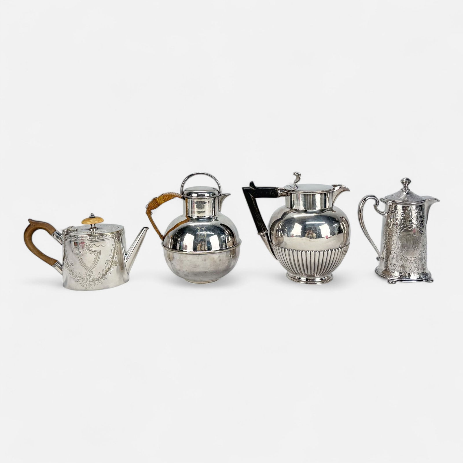 Group of Four Antique Victorian Jugs and Teapots: Good age-appropriate condition. Reed & Barton creamer measures approx. 5 3/4" x 4 1/2" x 2 3/4", Bernard Rice's Sons hot water pot measures approx. 6 1/2" x 5 1/4" x 4 1/4", William Hutton & Sons coff