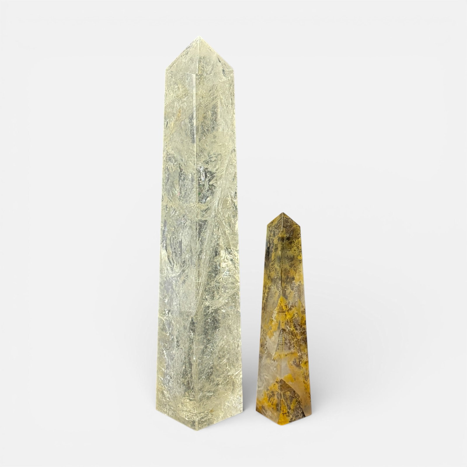 Two Contemporary 20thC Carved Hard Stone Moss Agate Quartz Table Obelisks: Good, with some minor dings to corners. Larger obelisk dimensions included in listing. Smaller obelisk measures approx. 8 1/2" x 1 5/8".For shipping, we highly recommend Donald Camden at UPS Store 460