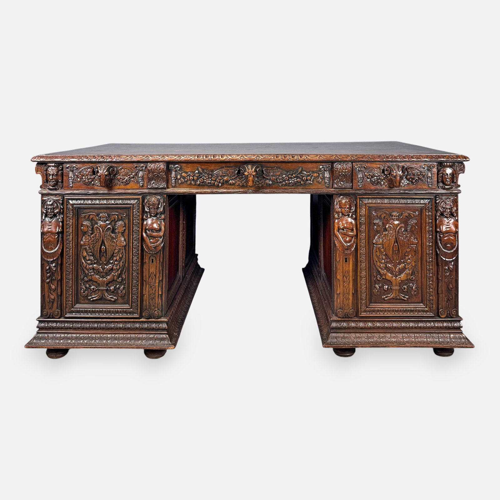 Antique Carved Walnut Kneehole Partners Desk w/High-Relief Rams-Head Handles and Angel Carvings: High-relief carving is featured on all sides. In addition to the fine high-relief carving the top has a fine checkerboard marquetry inlaid design. Raised on bun feet. Top and sides seperate for easy t