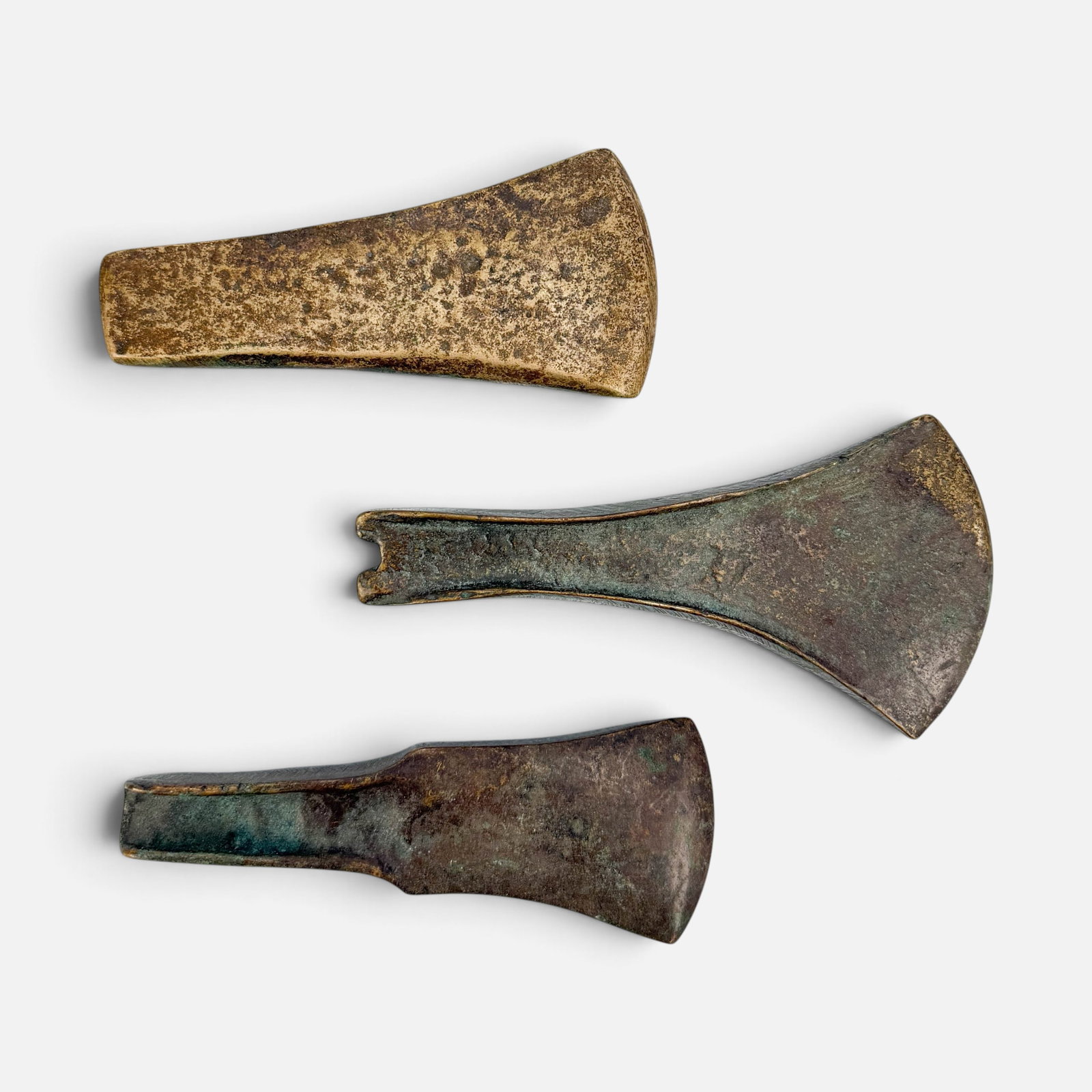 Three Ancient European Bronze Age Axe Heads: Largest axe head measures approx. H: 2 5/8", W: 5 1/4", D: 3/4". The smallest measures approx. H: 2 1/8", W: 4 1/2", D: 1/2". Good age-appropriate condition as shown. For shipping, we highly recommend