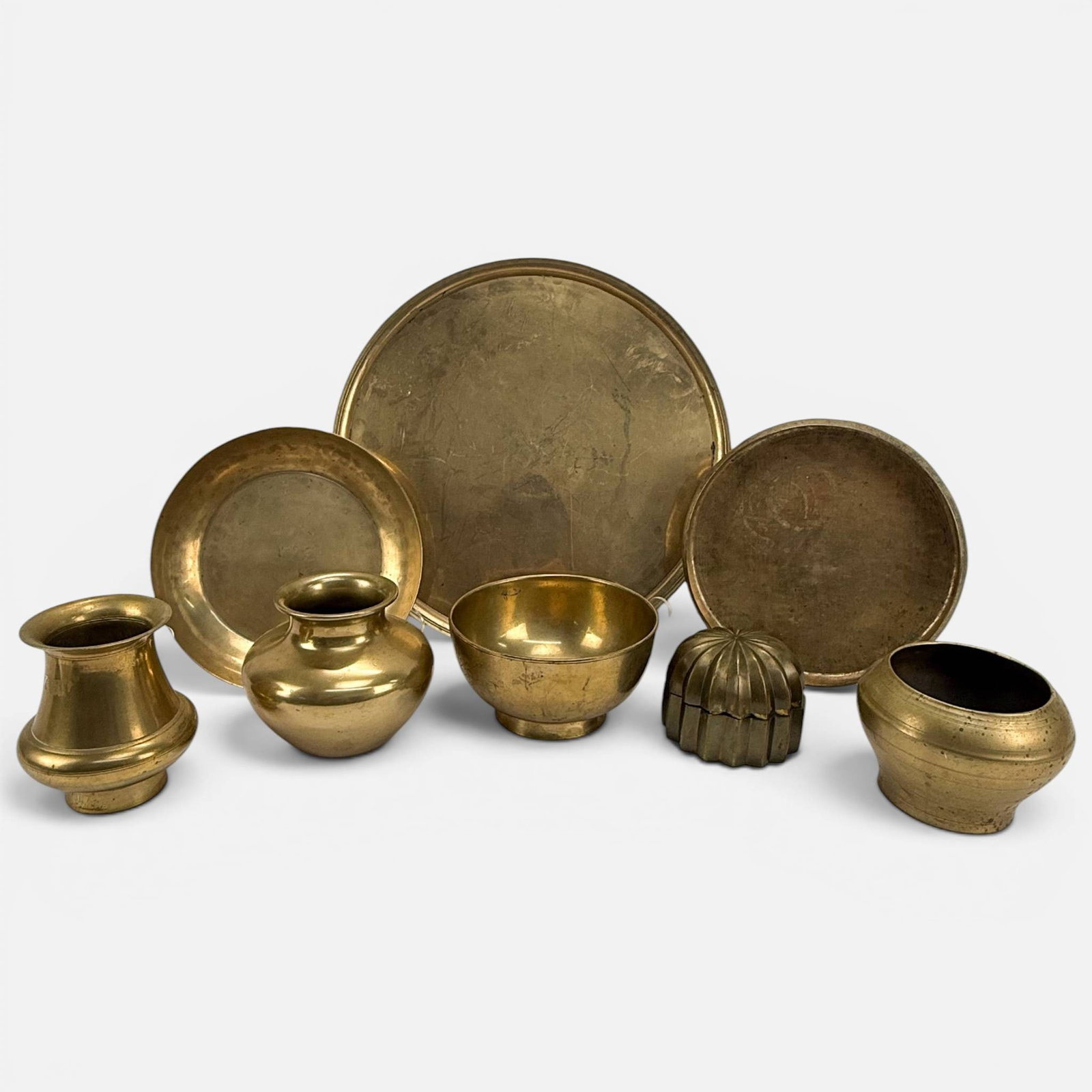 Eight Vintage/Antique South Asian Indian Brass Trays, Bowls, and Vases: Ca. late 19th to first half 20thC. Large tray measures approx. H: 1/2", 16 1/2" x 1/2". All village used material with age-appropriate wear throughout. For shipping, we highly recommend Donald Camden
