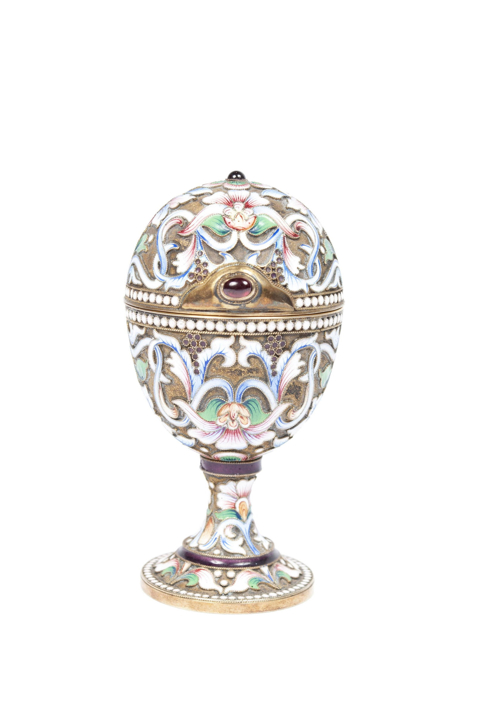 A FINE RUSSIAN ARTEL SILVER-GILT CLOISONNE ENAMELED AND: A FINE RUSSIAN ARTEL SILVER-GILT CLOISONNE ENAMELED AND JEWELED EGG ON STANDRussia, late 19th century, silver and polychrome enamel. Amethyst tone jewel to apex and centerpiece of hinged covering open