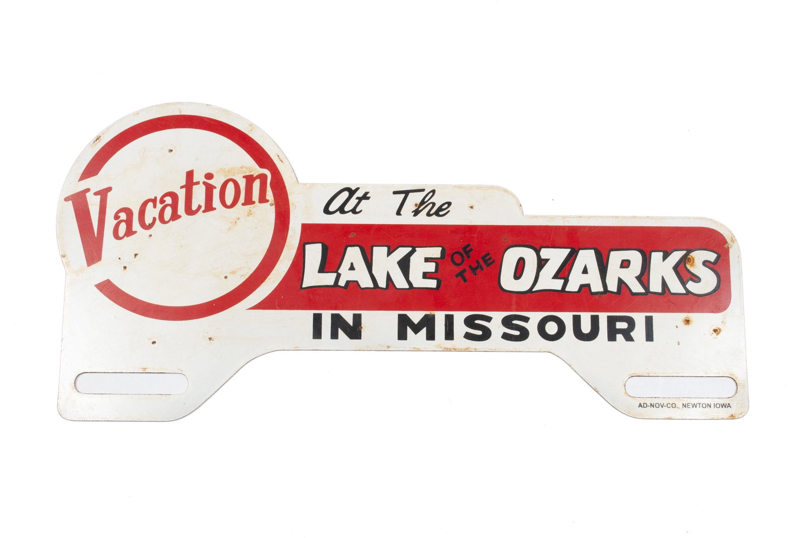 OZARKS LICENSE PLATE TOPPER: OZARKS LICENSE PLATE TOPPER White metal, reading: "Vacation at The Lake of The Ozarks in Missouri" with red and black highlights. 10" length
