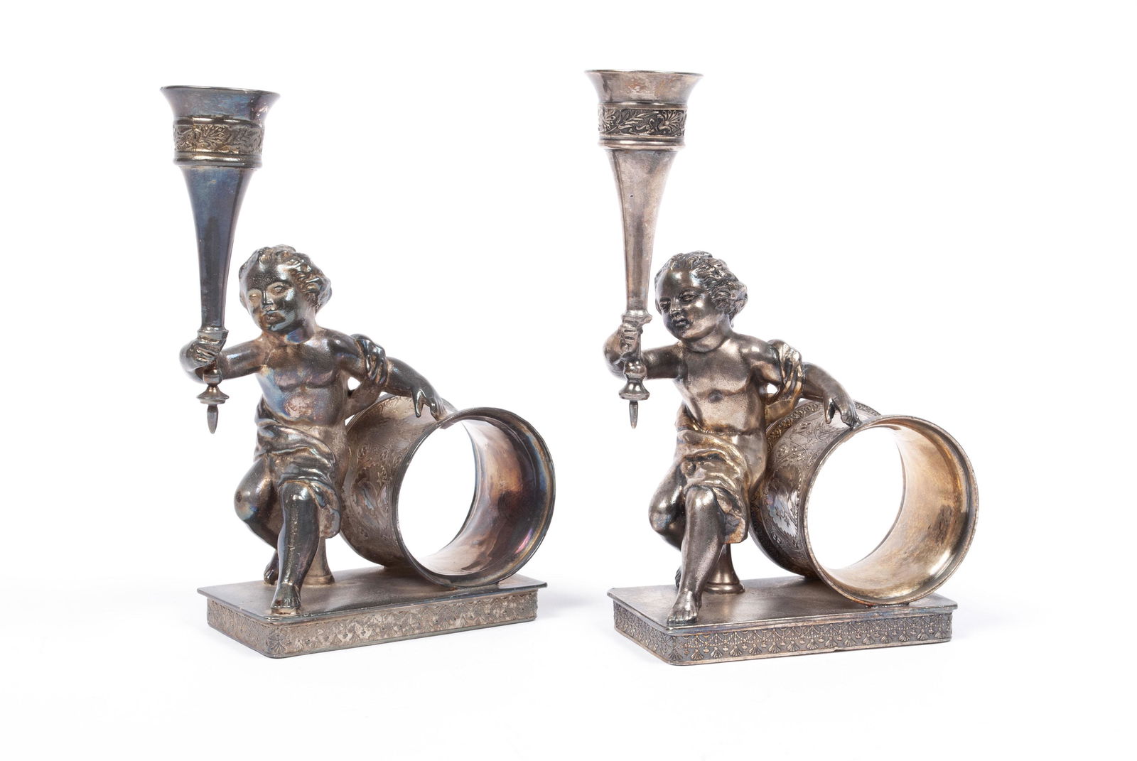 PAIR OF REED & BARTON NAPKIN RINGS WITH BUD VASES: PAIR OF REED & BARTON NAPKIN RINGS WITH BUD VASESReed and Barton, #1285. Cherub figures in dynamic poses hold a torch form bud vase with leaf pattern banding, ahead of a ring with detailed floral patt