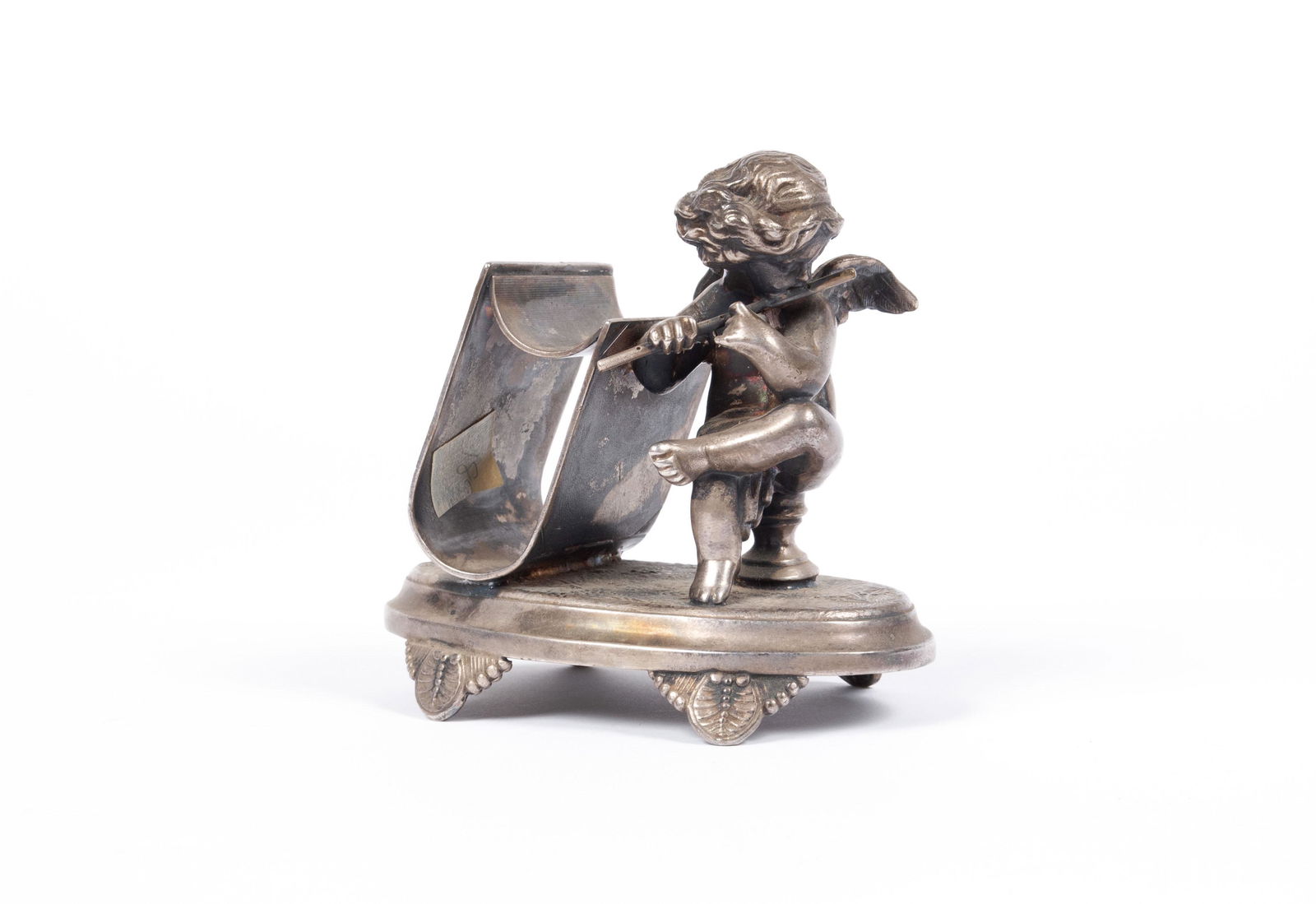 DENBY FLUTE-PLAYING CHERUB NAPKIN RING: DENBY FLUTE-PLAYING CHERUB NAPKIN RINGDenby #330, a winged cherub plays flute at the side of a ring shaped like a book with incised fan decoration to the cover, all atop an ovular base with four legs.