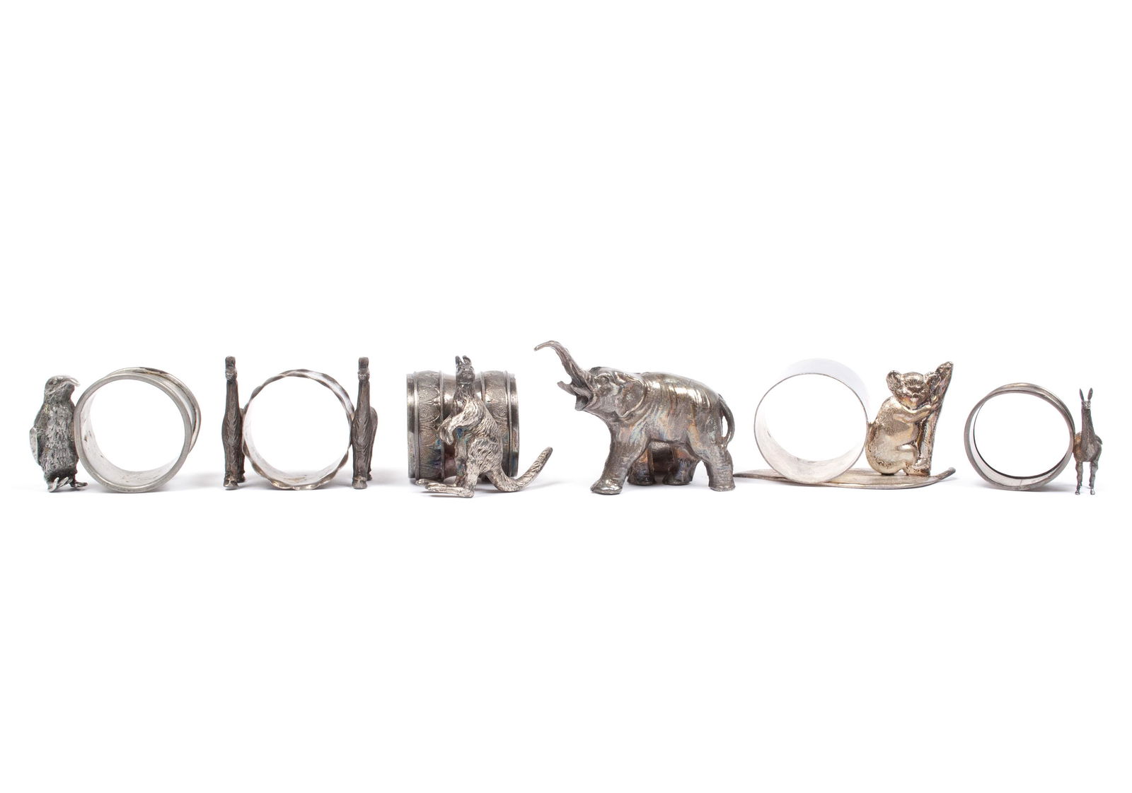 ASSORTMENT OF EXOTIC ANIMAL NAPKIN RINGS: ASSORTMENT OF EXOTIC ANIMAL NAPKIN RINGSAll unmarked. An elephant with rose and butterfly designs to ring, a penguin with a plain ring, a koala on branch with plain ring and leaf base, a kangaroo with