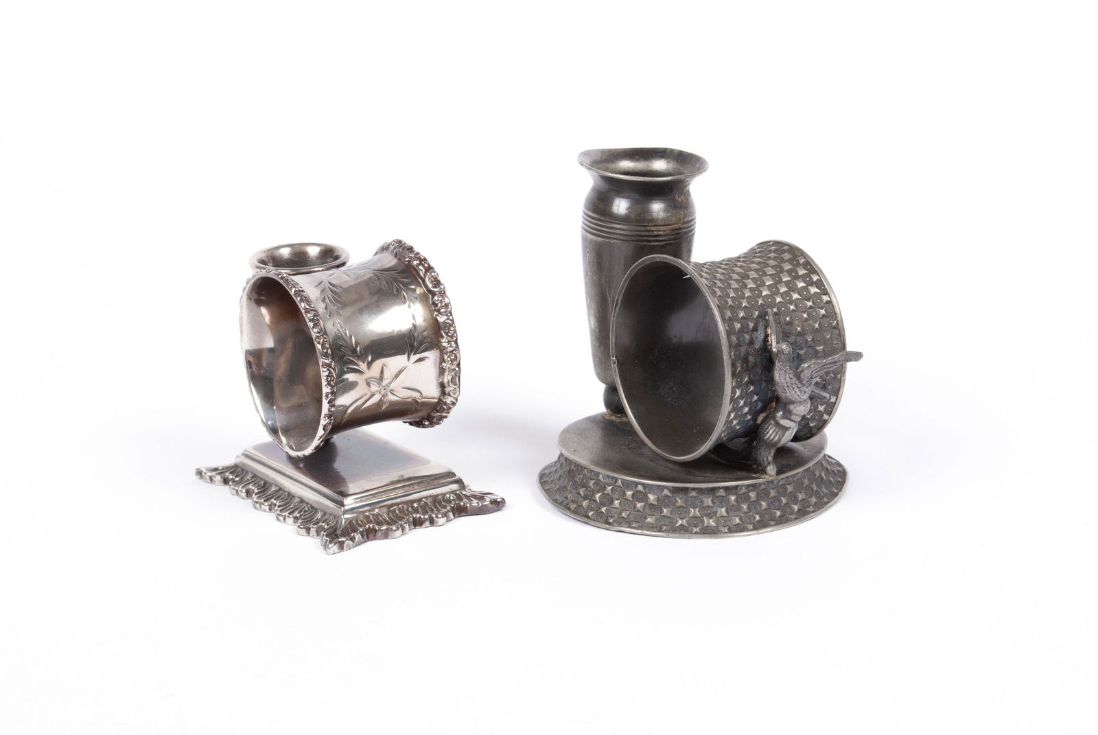 TWO BUD VASE NAPKIN RINGS: TWO BUD VASE NAPKIN RINGSOne Rockford #177 with relief stud design throughout ring and base, with bird figural at the side of the ring, together with one (Taunton) Poole # 123 on rectangular, foliate