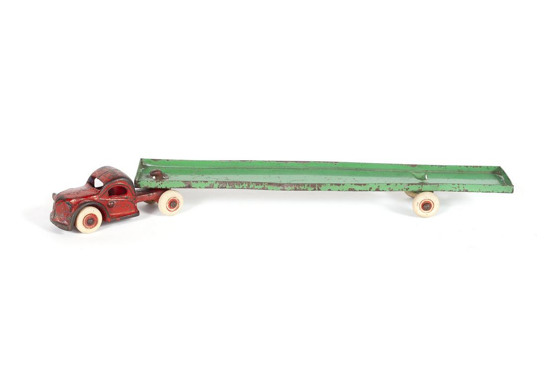 ARCADE CAST IRON TRANSPORTER TRUCK & TRAILER: ARCADE CAST IRON TRANSPORTER TRUCK & TRAILER American, ca. 1930. With cast iron truck cab and pressed steel trailer with rubber wheels. 14.25" length