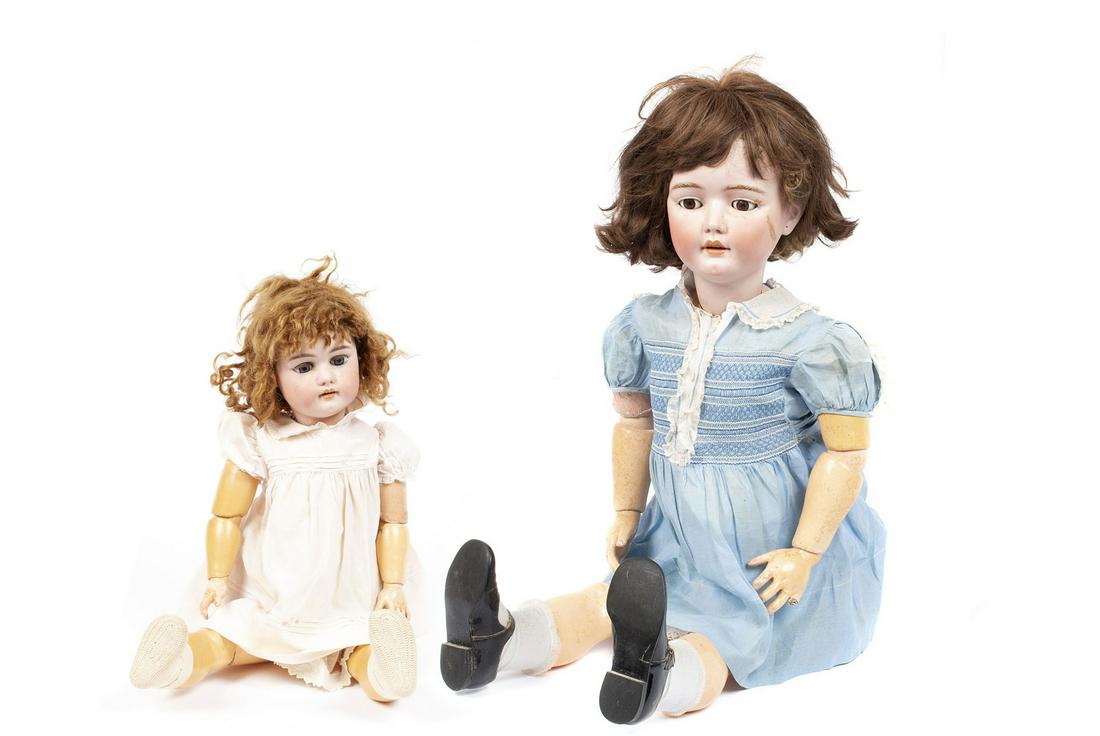 TWO BISQUE HEAD AND PAPIER MACHE DOLLS: TWO BISQUE HEAD AND PAPIER MACHE DOLLSGermany, mid-20th century. The smaller doll in white dress with open mouth and pierced ears is marked "Germany" and "14" to the back with an orange inked oval sta