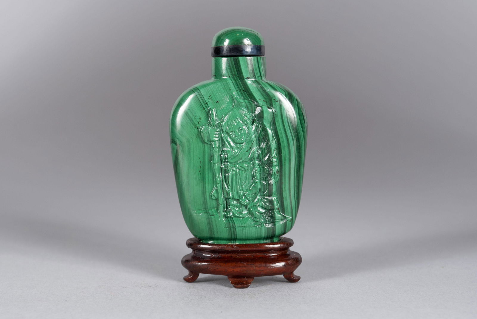 PURSUIT OF PLUM MALACHITE DOUBLE CARVED CHINESE SNUFF: PURSUIT OF PLUM MALACHITE DOUBLE CARVED CHINESE SNUFF BOTTLEChina, late 19th- early 20th century. Jadeite stopper with onyx collar, travelers in pursuit of plum carved to both sides, together with sta