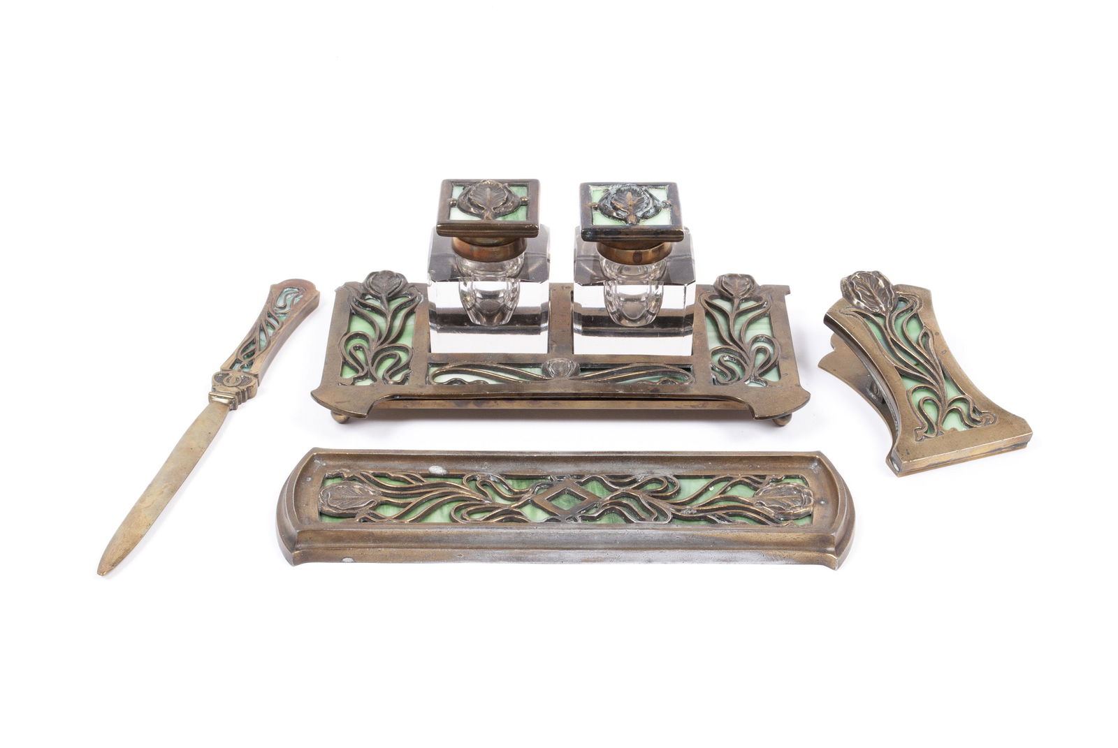 APOLLO STUDIOS ARTS & CRAFTS DESK SET: APOLLO STUDIOS ARTS & CRAFTS DESK SETOpenwork gilt metal framework in Art Nouveau floral design with slag glass underlayer, including encrier with two lidded glass inkwells, a letter opener, pen rest,