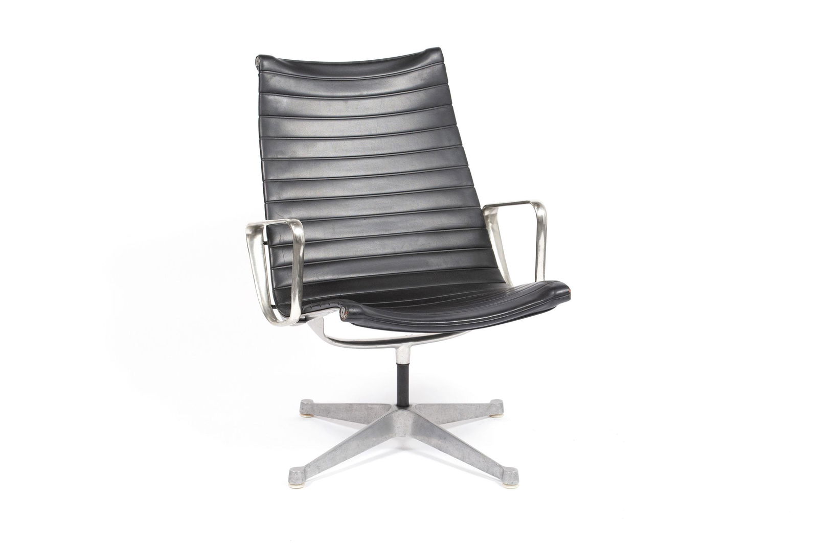 CHARLES EAMES FOR HERMAN MILLER ALUMINUM GROUP LOUNGE: CHARLES EAMES FOR HERMAN MILLER ALUMINUM GROUP LOUNGE CHAIRAmerican, mid-20th century. Early production ribbed black naugahyde upholstery to stationery Aluminum Group swiveling base. 34.25" height, 25