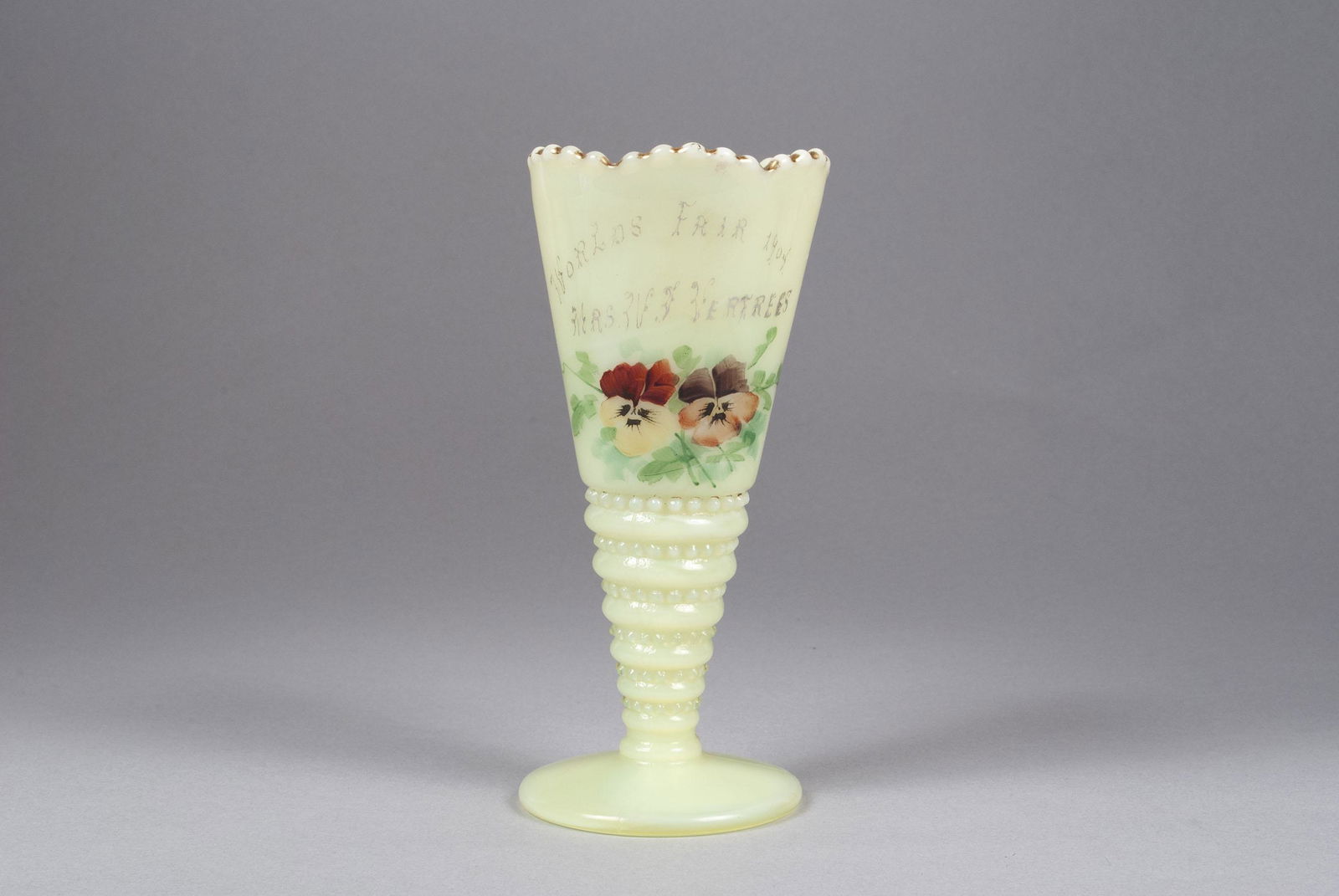 1904 ST. LOUIS WORLD'S FAIR CUSTARD GLASS: 1904 ST. LOUIS WORLD'S FAIR CUSTARD GLASSSoft green milk glass, gilt accents, with hand-painted floral decor, text: "Mrs. Vertress; World's Fair 1904". 6.25" height