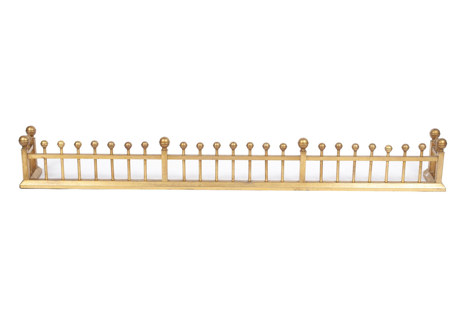 LOW FIREPLACE FENDER: LOW FIREPLACE FENDER Late 19th/ early 20th century Thick brass fence form with plain spindles and ball finials, iron frame beneath. 9.75" height, 74" length