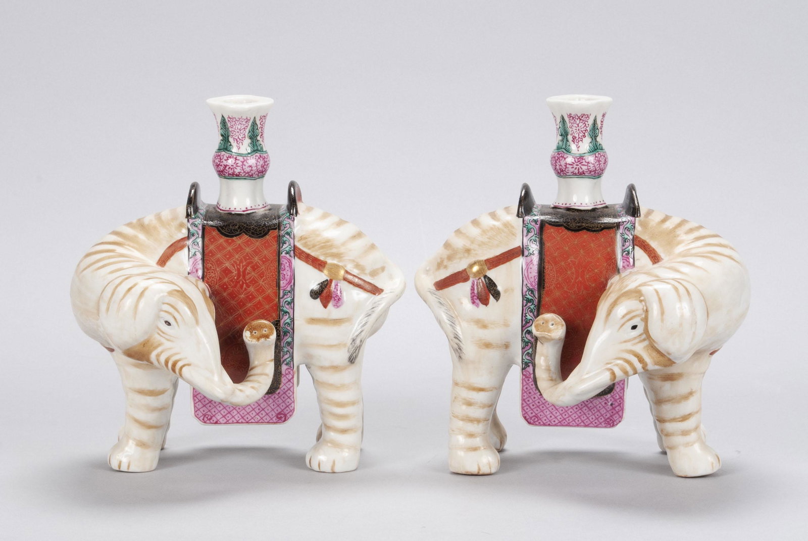 PAIR OF WINTERTHUR MOTTAHEDEH ELEPHANT CANDLESTICKS: PAIR OF WINTERTHUR MOTTAHEDEH ELEPHANT CANDLESTICKS Polychrome porcelain figures with holders inset to enameled saddleblankets. 10" heights