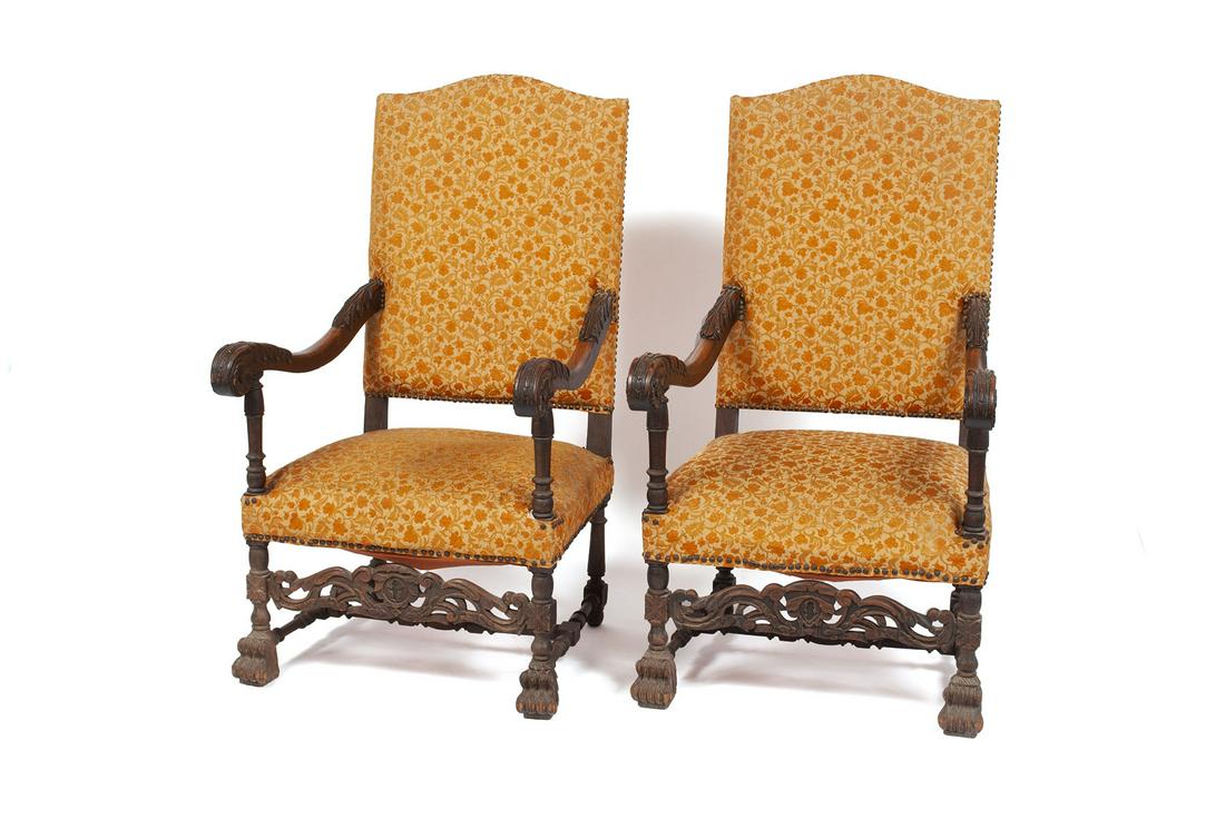 PAIR OF 19TH CENTURY FLEMISH ARMCHAIRS: PAIR OF 19TH CENTURY FLEMISH ARMCHAIRS Continental, mid to late 19th century. Tall squared backs, scrolling arms, elaborately carved stretcher bar and terminating on robust paw inspired footing. 48" h