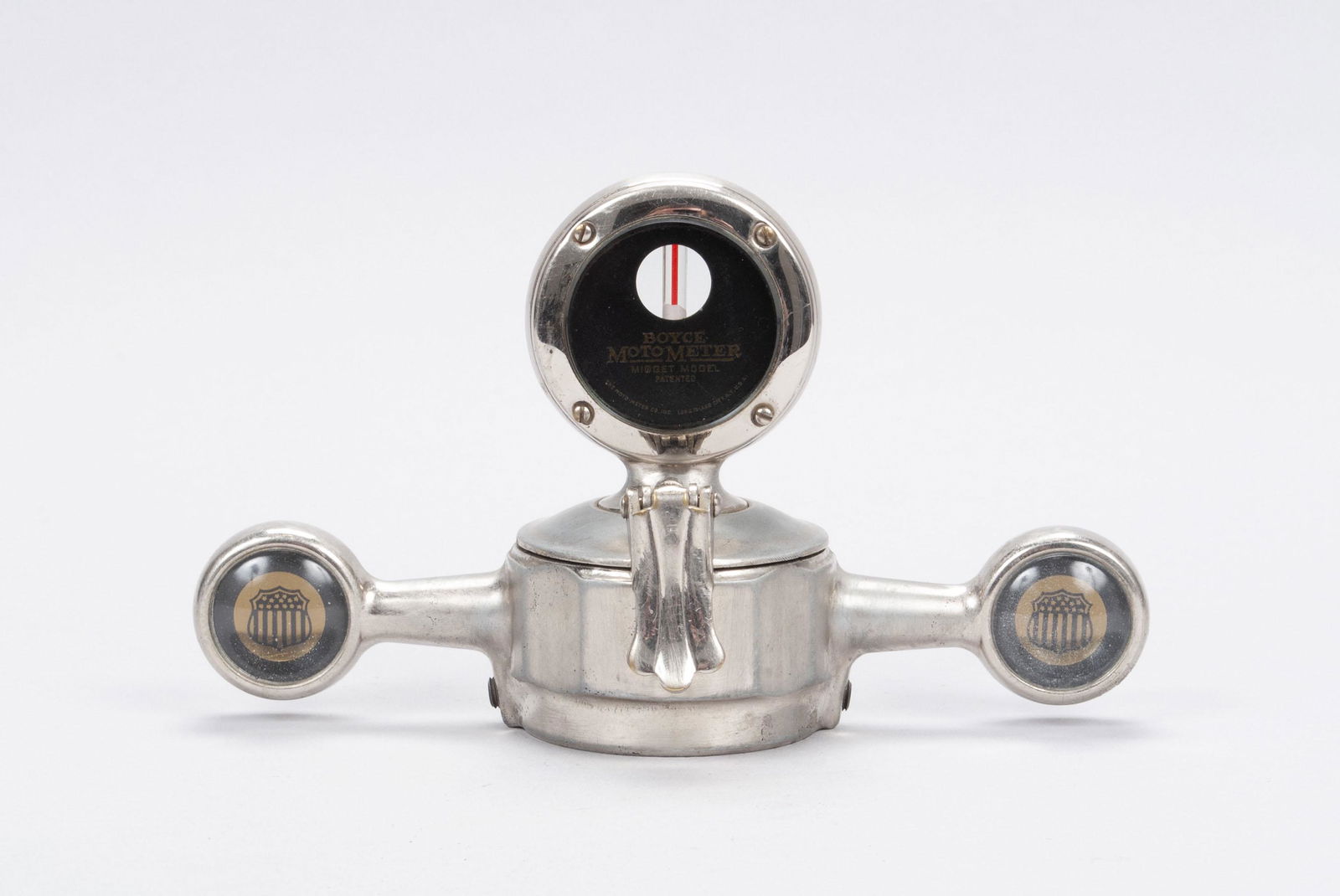 BOYCE MOTOMETER ON DOG BONE CAP: BOYCE MOTOMETER ON DOG BONE CAPDog bone showing shield form flag ornaments to each knob end. 7.25" width