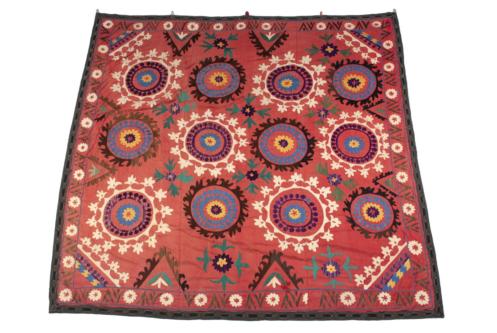 UZBEK TACKING SILK EMBROIDERED SUZANI: UZBEK TACKING SILK EMBROIDERED SUZANI Central Asia, late 19th Century, alternating rosette pattern on red field, with tacking and diagonal border. 56" length, 72" width