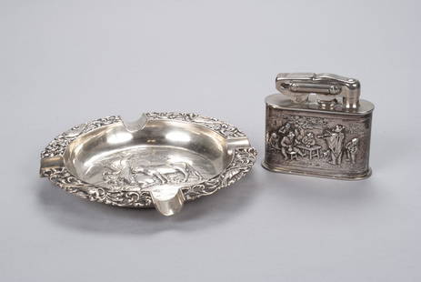 TWO DUTCH HALLMARKED SILVER SMOKING ARTICLES: TWO DUTCH HALLMARKED SILVER SMOKING ARTICLESNetherlands, both fully hallmarked. An openwork filigree and aviary ashtray (1922) with pastoral scene to the bowl, together with a table lighter (1927)