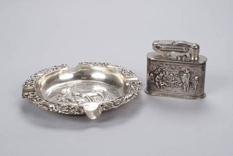 TWO DUTCH HALLMARKED SILVER SMOKING ARTICLES: TWO DUTCH HALLMARKED SILVER SMOKING ARTICLESNetherlands, both fully hallmarked. An openwork filigree and aviary ashtray (1922) with pastoral scene to the bowl, together with a table lighter (1927)