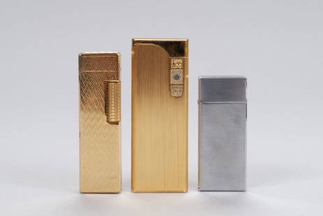 TRIO VINTAGE CIGARETTE CIGAR LIGHTERS: TRIO VINTAGE CIGARETTE CIGAR LIGHTERSTwentieth century. Gold tone Colibri touch sensor lighter in original box, NOS; silver toned Colibri Zippo style; and Petersons gold tone diamond patterned side