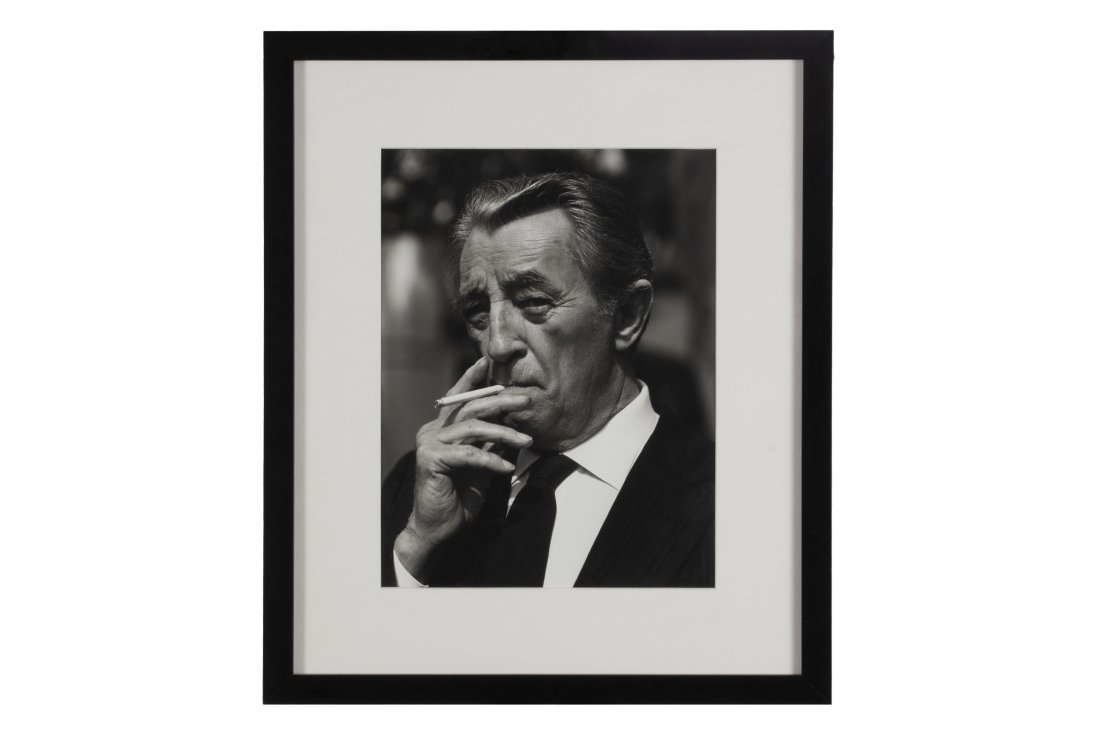 BRUCE WEBER (AMERICAN, B. 1946): Robert Mitchum Silver gelatin print, Santa Barbara, CA, 1991, edition 3/20. Pencil signed, dated, and editioned to verso. A bust portrait of the actor with cigarette. Matted behind glass, ebonized fra