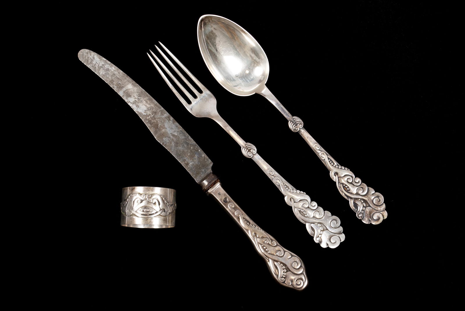 FOUR PIECES EVALD NIELSEN SILVER: FOUR PIECES EVALD NIELSEN SILVERDenmark, ca.1919. Knife, fork, spoon and napkin ring, all monogrammed "F.E." with "Xmas 1919". All four bear the Copenhagen hallmark with all three utensils bearing the