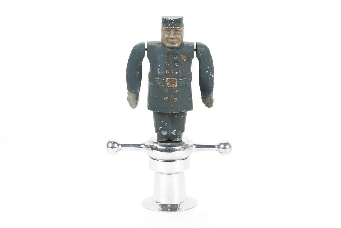 KEYSTONE COP WHIRLIGIG HOOD ORNAMENT MASCOT: KEYSTONE COP WHIRLIGIG HOOD ORNAMENT MASCOT American, aluminum. Patent pending markings to backside of belt, on dog bone mount. 9.75" height