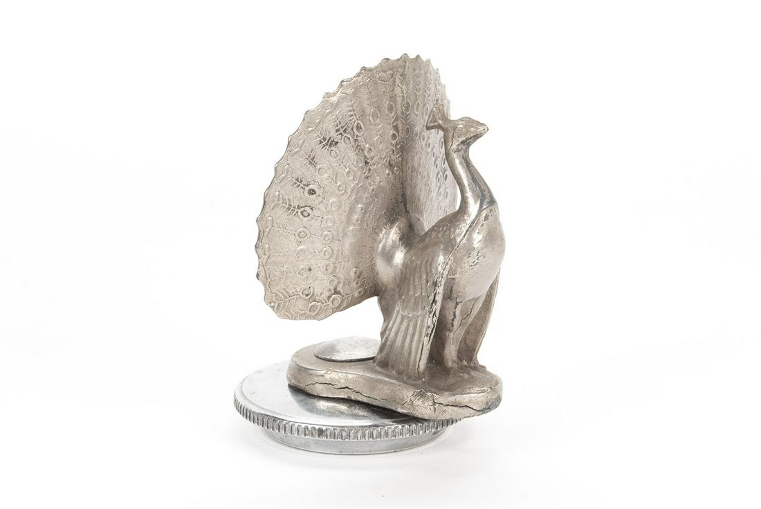 PEACOCK HOOD ORNAMENT MASCOT: PEACOCK HOOD ORNAMENT MASCOT American, 2nd quarter 20th century. Majestic pose with detailed fan-form feathers up, mounted on radiator cap. 5" height
