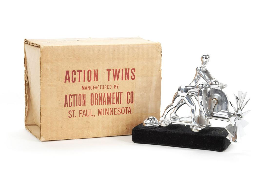 ACTION TWINS FIGURAL HOOD ORNAMENT MASCOT WITH ORIGINAL BOX: ACTION TWINS FIGURAL HOOD ORNAMENT MASCOT WITH ORIGINAL BOX American, ca. 1930s, chrome, manufactured by Action Ornament Co., St. Paul, MINN, with patent #. Interactive ornament showing twin figures c