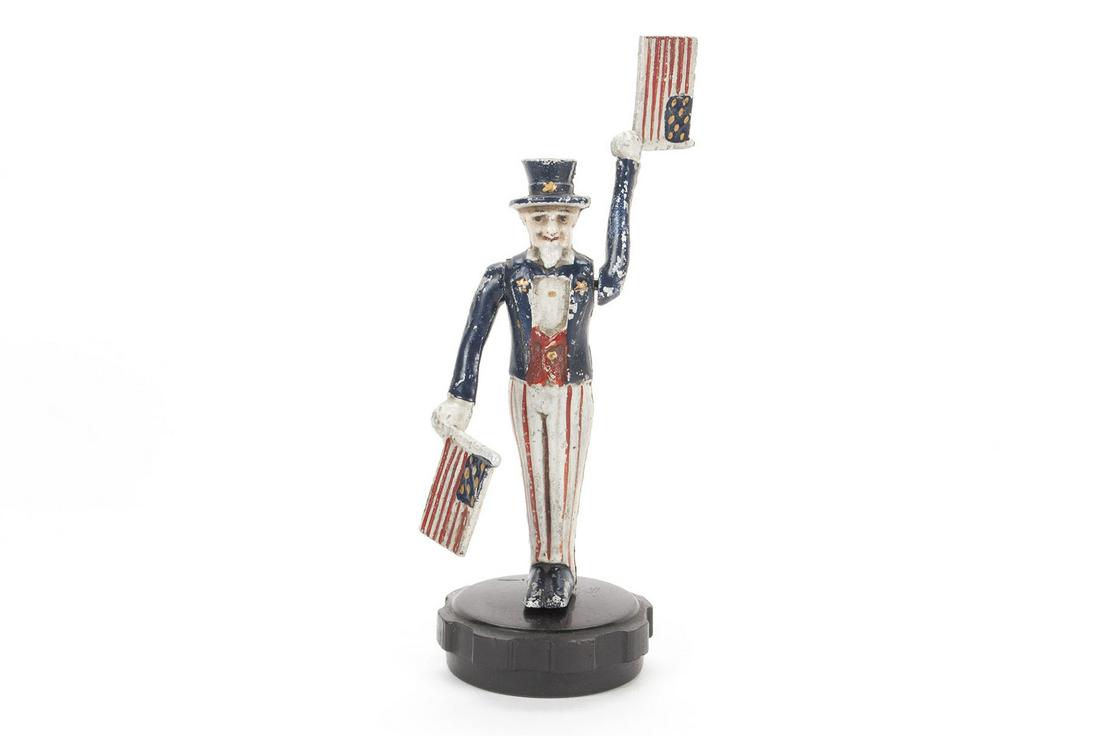 UNCLE SAM WHIRLIGIG HOOD ORNAMENT MASCOT: UNCLE SAM WHIRLIGIG HOOD ORNAMENT MASCOT American, ca. 1920. Standard patriotic uniform, waving flags, mounted on radiator cap. 6.5" height
