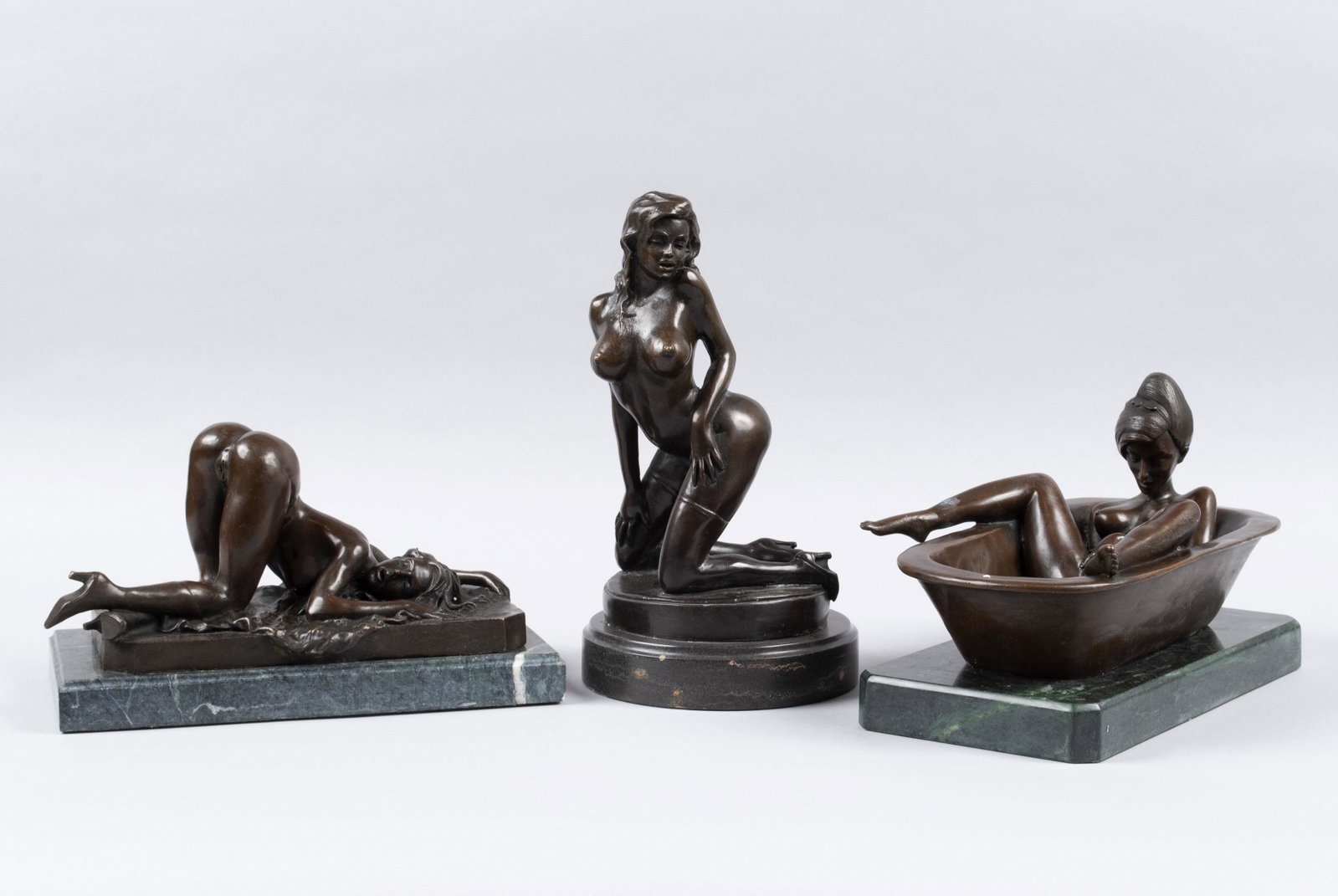 TRIO OF EROTIC FEMALE BRONZES: TRIO OF EROTIC FEMALE BRONZES Twentieth century, bronze. Two with Bronze Masters seal marks, one of which is signed J. Roux. Including bathing figure on green marble base, another reclined figure with