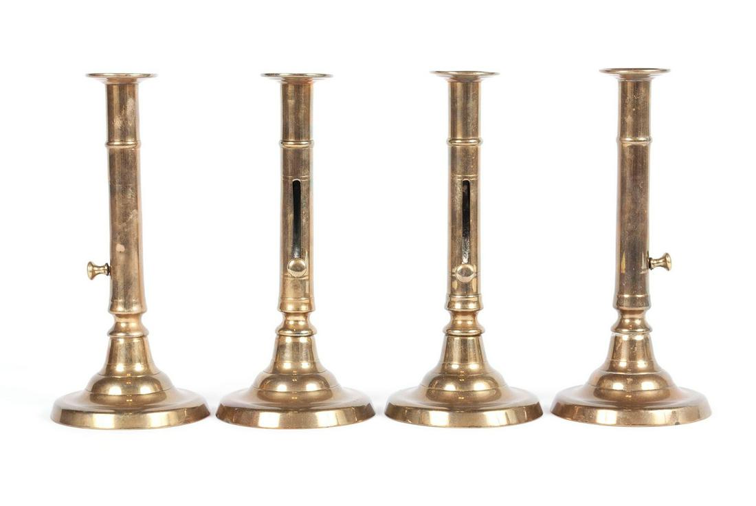 SET OF FOUR GEORGIAN BRASS PUSH-UP CANDLESTICKS: SET OF FOUR GEORGIAN BRASS PUSH-UP CANDLESTICKS England, ca. 1800. Turned stems with push-up levers and circular bases. Height: 8 3/4 in. (22.23 cm.)