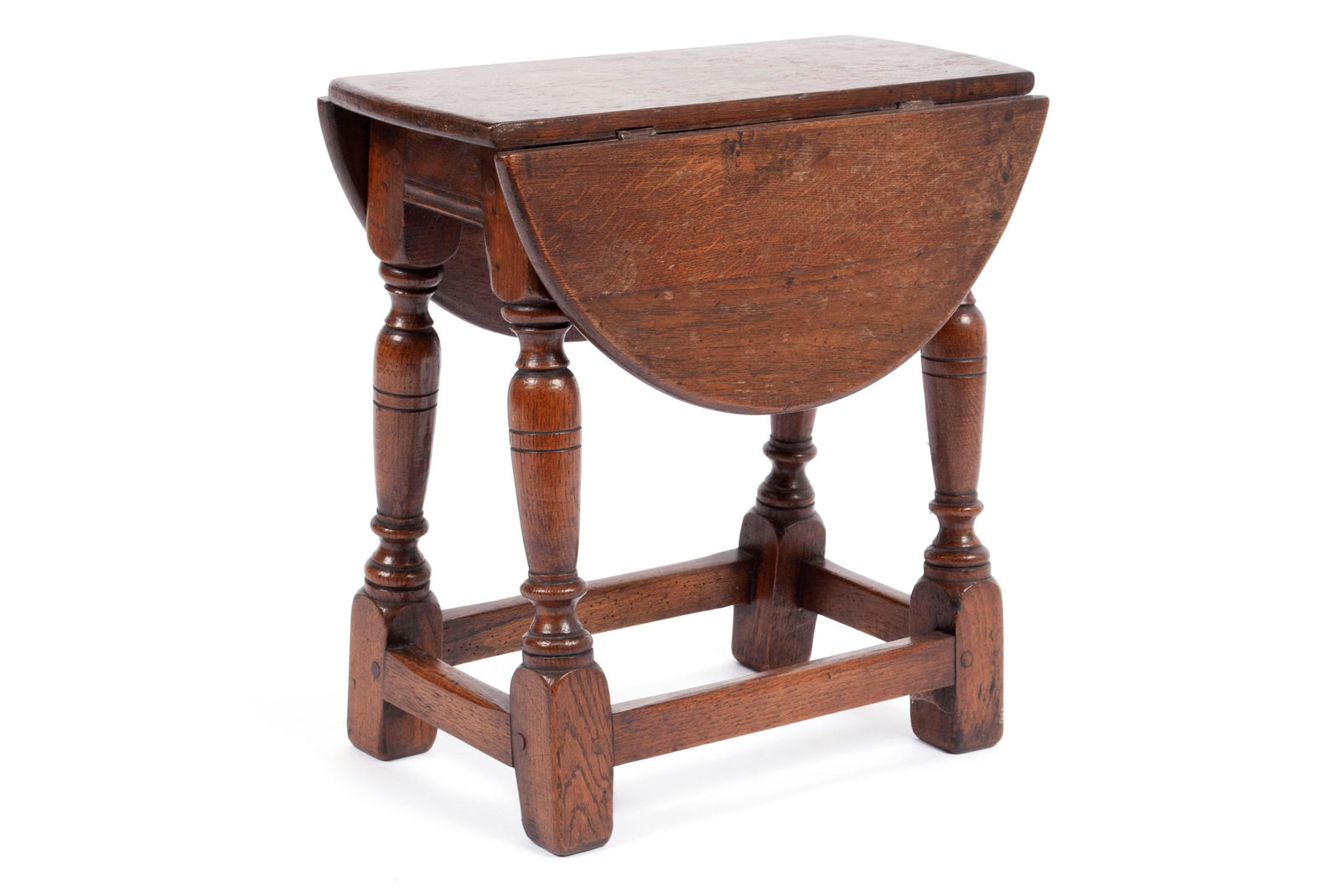MINIATURE OAK DROP LEAF TABLE: MINIATURE OAK DROP LEAF TABLEEngland, late 19th/20th century. Two leaves over four turned and splayed legs with box stretcher over square feet.18 x 8 1/2 x 18 in. (45.72 x 21.59 x 45.72 cm.)