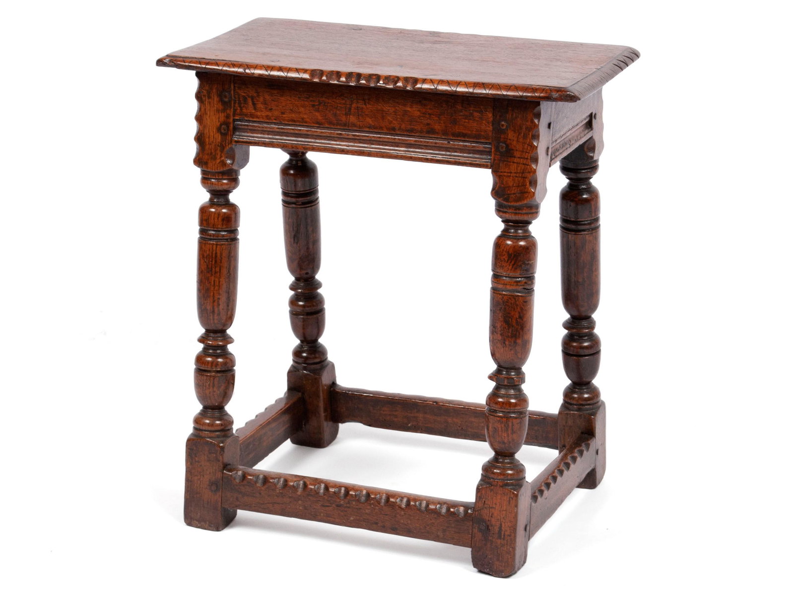 18TH C. ENGLISH JOINT STOOL: 18TH C. ENGLISH JOINT STOOL English, 18th century. Rectangular top with simple geometric carving, plain frieze with molded lower rails on turned legs with box stretcher at the floor. 21 1/4 x 18.80 x 