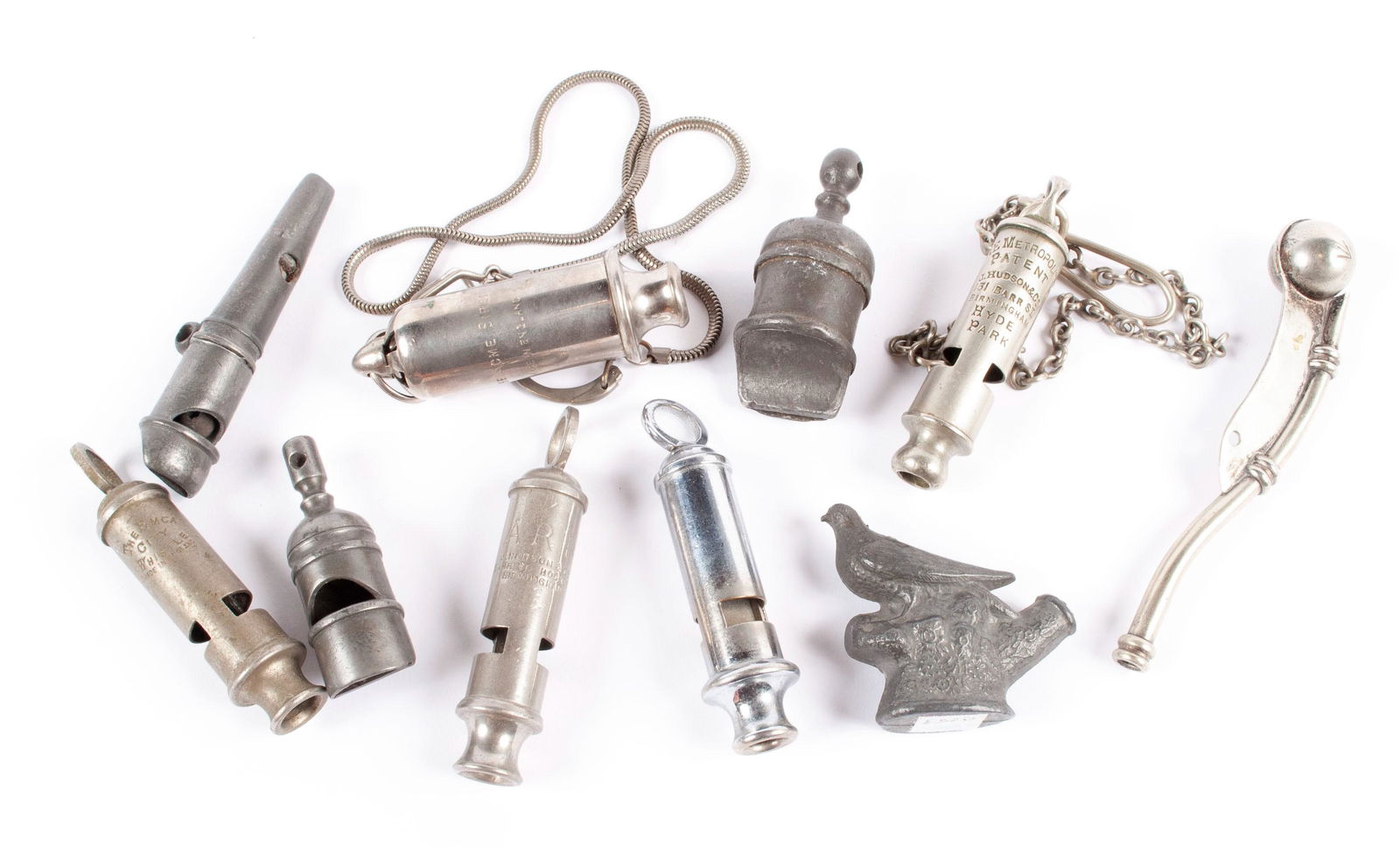 EIGHT ENGLISH WHISTLES: EIGHT ENGLISH WHISTLESSeveral pewter and others, including a Metropolitan Birmingham "Hyde Park" on fob, two ARP by Hudson, "The Emca City", The "Acme Siren" and others.