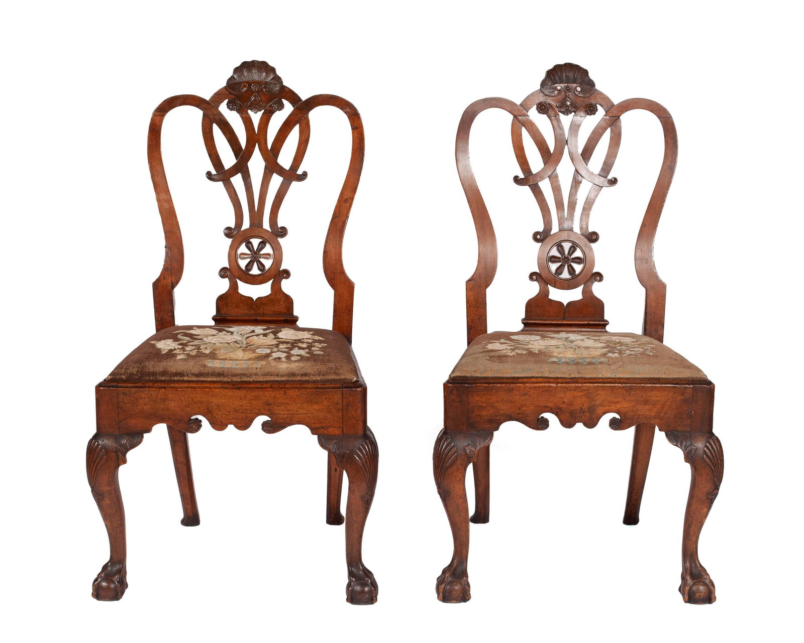 PAIR OF WELL-CARVED CHIPPENDALE SIDE CHAIRS: PAIR OF WELL-CARVED CHIPPENDALE SIDE CHAIRS American, 20th century design, mahogany. Finely carved, pierced splats with wheel designs, floral upholstered seats, scrolling aprons, and cabriole front le