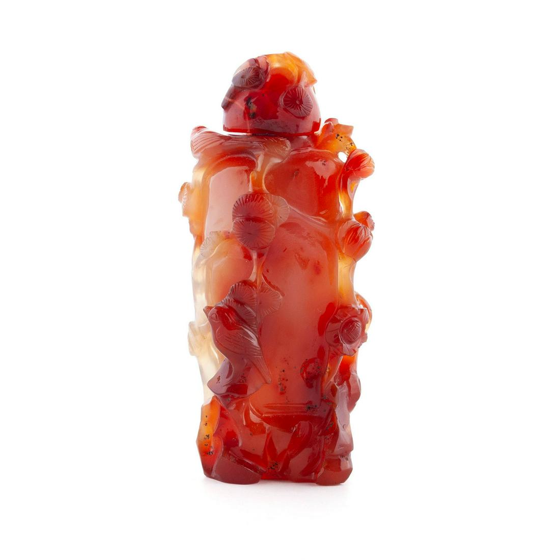 A RELIEF CARVED BOTANICAL CARNELIAN SNUFF BOTTLE: A RELIEF CARVED BOTANICAL CARNELIAN SNUFF BOTTLE Chinese, early 20th century, agate. The milky white to dark red, tall bottle skillfully carved with flowering vines and birds; matching, carved stopper