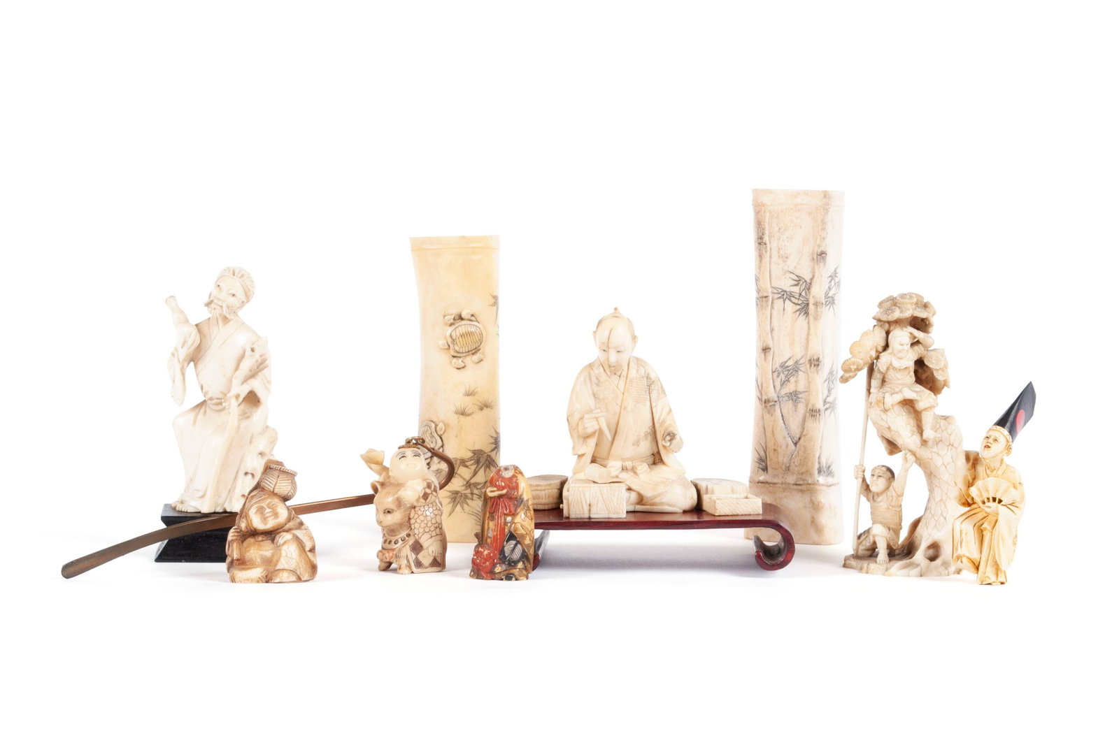 NINE CARVED JAPANESE FIGURES: NINE CARVED JAPANESE FIGURES Japanese, early 20th century. Seven okimono and netsuke figures in various human forms, together with two brush pots. Tallest: 5 1/2 in. (13.97 cm.)