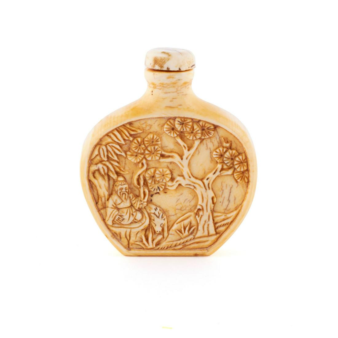 A CARVED GENRE SCENE SNUFF BOTTLE: A CARVED GENRE SCENE SNUFF BOTTLE Chinese, 20th century, organic material. The ovate, flattened "moon flask" bottle finely relief-carved with a travelling figure atop an ox to one side, the 