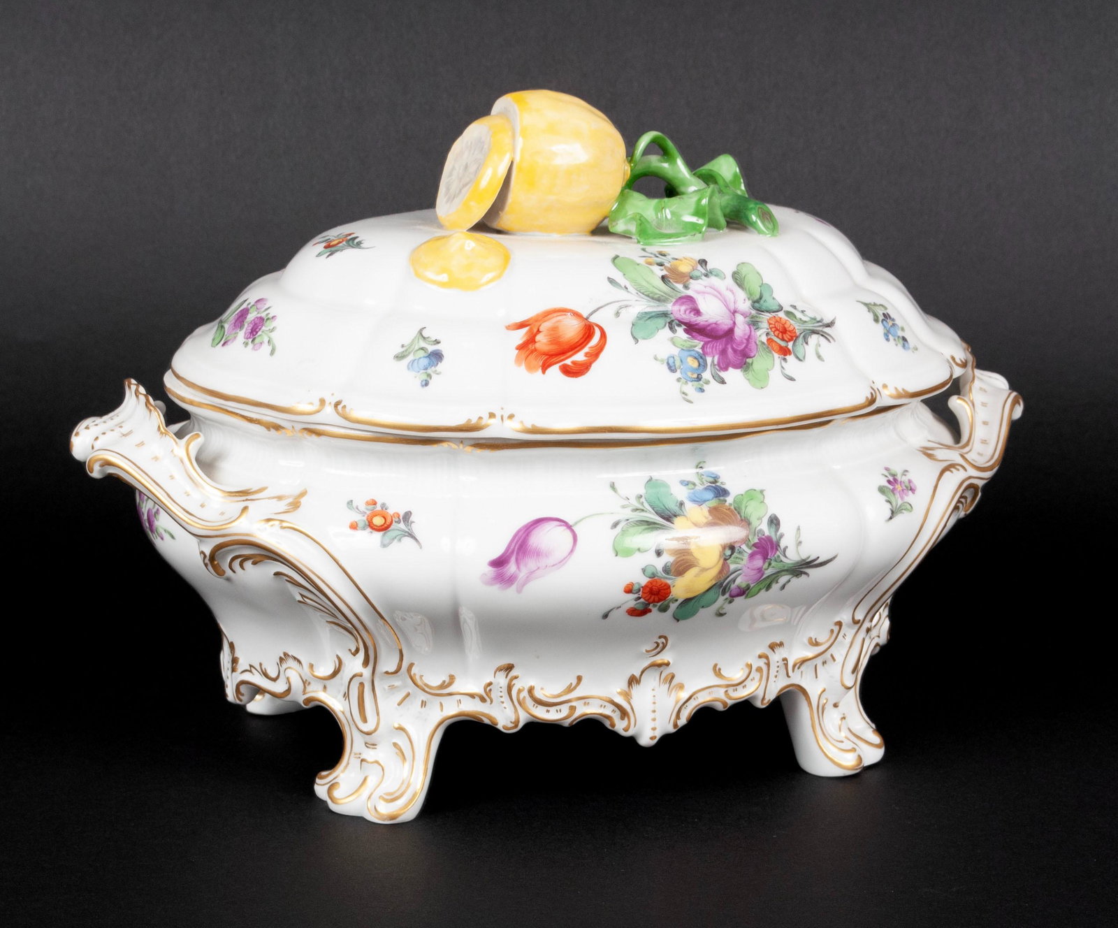 NYMPHENBURG HAND-PAINTED LEMON TUREEN: NYMPHENBURG HAND-PAINTED LEMON TUREEN German, 1930's, porcelain. The tureen lid with applied lemon finial atop the vessel of brightly hand-painted flowers and relief gilt decoration, raised on four ou